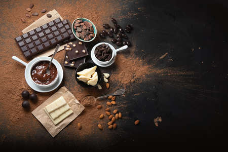 Dark chocolate bar,chocolate pieces and cocoa beans, cocoa powder on black