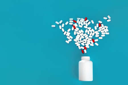 Heap of pills on blue background. Top view with copy space