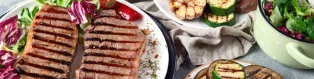 Grilled beef steaks with vegetables. top view , panorama, banner