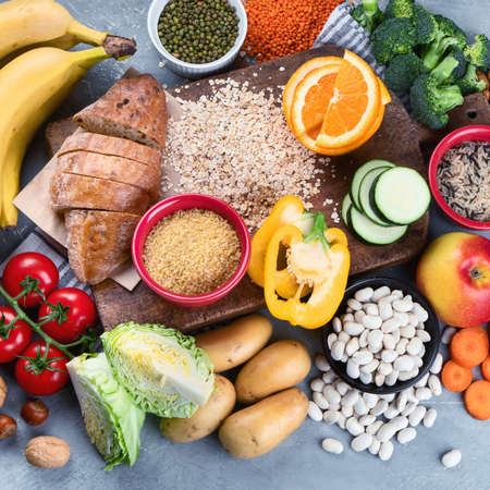 Foods high in carbohydrates on grey background. Vegan Foods high in dietary fiber, antioxidants, vitamins and minerals. Top viewの写真素材