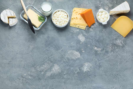 Different types of dairy products on grey background. Top view with copy space