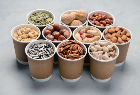 Different types of Nuts in ecofriendly cups high in vegan protein, vitamins and antioxidants for immune system boosting. Ecofriendly concept. の写真素材