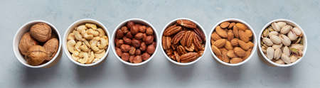 Different types of Nuts in ecofriendly cups high in vegan protein, vitamins and antioxidants for immune system boosting. Ecofriendly concept. Top view. Panorama, bannerの写真素材