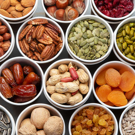 Different types of Nuts in ecofriendly cups high in vegan protein, vitamins and antioxidants for...