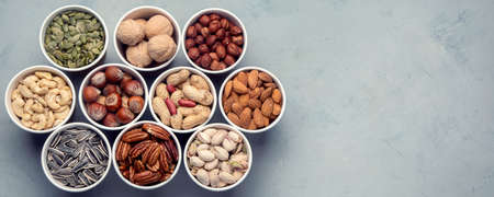 Different types of Nuts in ecofriendly cups high in vegan protein, vitamins and antioxidants for immune system boosting. Ecofriendly concept. Top view with copy space. Panorama, bannerの写真素材