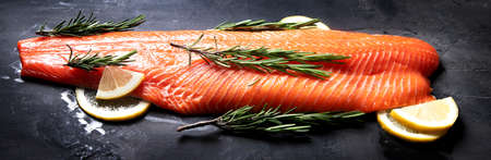 Fresh fish. Raw salmon on black background. Panorama, bannerの写真素材
