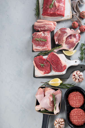 Assortment of raw meats on gray background. Top view with copy spaceの写真素材