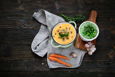 Vegetables cream soups on dark wooden background. Top view with copy spaceの写真素材