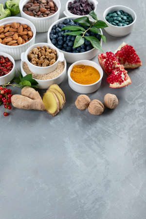 Bowls of various superfoods on gray background. Healthy organic food. Clean eating. View from above.の写真素材