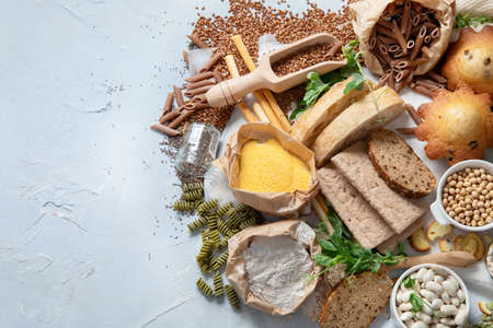 Different types of high carbohydrate food. Selection of good sources of carbs on gray background. Top view, flat lay with copy space.の写真素材
