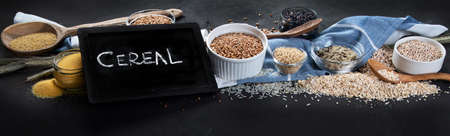 Different types of cereals in bowls on black background. Healthy nutrition eating. Top view....