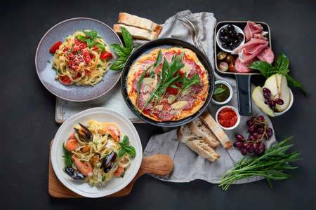 Italian food on dark background with pasta, pizza, top view,の写真素材