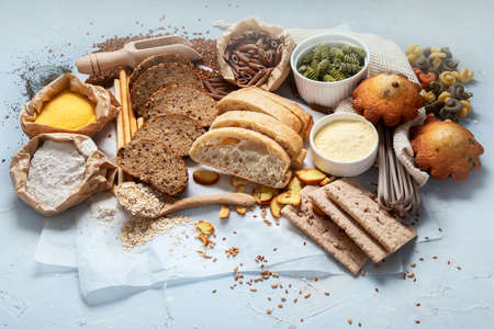 Different types of high carbohydrate food. Selection of good sources of carbs on gray background.の写真素材