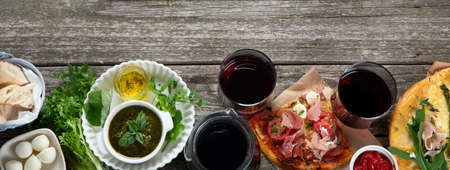 Appetizing classic Italian cuisine on rustic wooden table. Different types of pizza, pasta, snacks and capreze. Healthy homemade food. Top view, flat lay with copyspace.の写真素材
