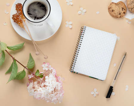Morning cup of coffee, empty notebook, snacks and hydrangea flowers. Top view, flat lay.の写真素材