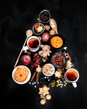 Christmas Tree made of holiday food on black background. Top view, flat lay with copy space. Christmas concept. New Year Holidays background.の写真素材