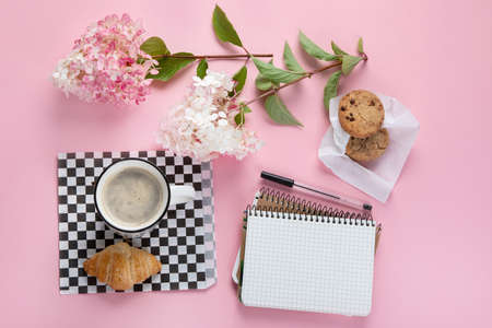 Morning cup of coffee, empty notebook, snacks and hydrangea flowers. Top view, flat lay.