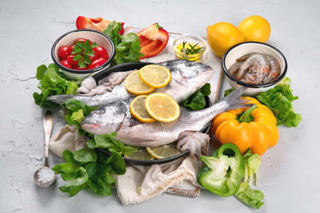 Raw dorado fish with vegetables. Top viewの写真素材