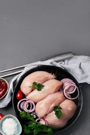 Fresh raw chicken fillet with spices, herbs and vegetables. Preparing dinner. Top view, copy spaceの写真素材
