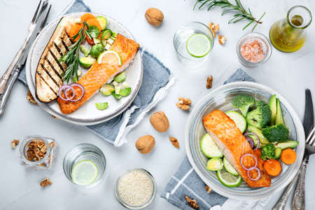 Two portions of homemade fresh salmon with vegetables on a light background. Healthy food concept. Top viewの写真素材