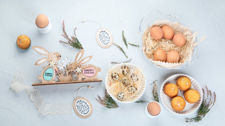 Easter composition with eggs and colorful sweets on light gray background. Seasonal holiday concept....