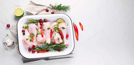 Raw chicken meat in pan, chicken legs with herbs. Top view with copy space. Panorama, banner