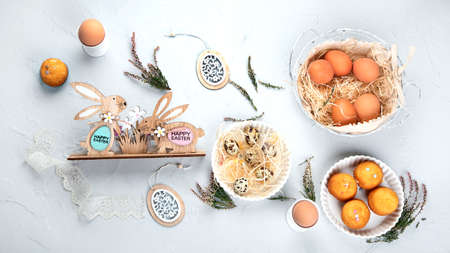 Easter composition with eggs and colorful sweets on light gray background. Seasonal holiday concept....