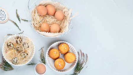 Easter composition with eggs and colorful sweets on light gray background. Seasonal holiday concept. Top view, copy spaceの写真素材