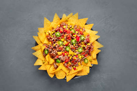 Delicious hispanic mexican meal board with nachos, beef, guacamole, avocado and starfruit. Hot and...