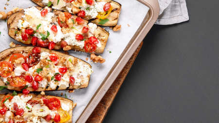 Fresh baked eggplants with walnuts and pomegranate. Delicious summer snack. Top view, copy spaceの写真素材