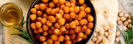 Vegan healthy snack, homemade roasted chickpeas in bowl on light gray background. Healthy food concept. Top view, panoramaの写真素材