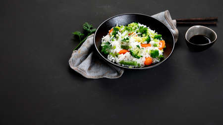 Fresh and healthy vegan rice bowl served with broccoli, carrot and spring onion with chopsticks on the side. Copy space, panorama bannerの写真素材