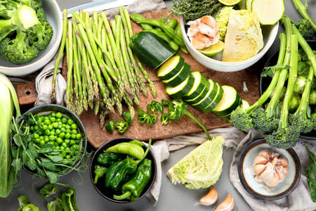 Set of various green vegetables and fruits like cabbage, broccoli, asparagus, peas, Brussels sprouts, zucchini, peppers, garlic, beans, pak choy, lime, apple. Healthy and nutricious vegetarian meal. Source of proteins and cellulose. Top viewの写真素材