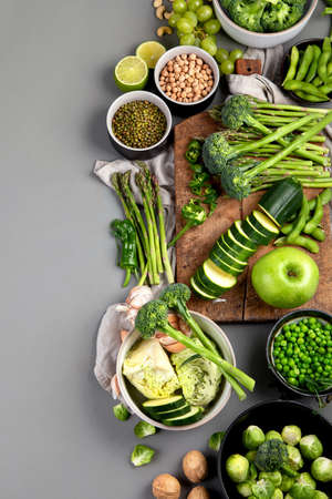 Set of various green vegetables and fruits like cabbage, broccoli, asparagus, peas, Brussels sprouts, zucchini, peppers, garlic, beans, pak choy, lime, apple. Healthy and nutricious vegetarian meal. Source of proteins and cellulose. Top view, copy spaceの写真素材