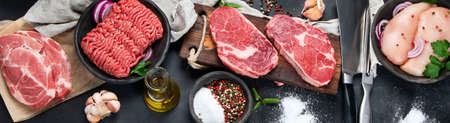 Variety of raw meat with seasoning on dark background. Top view, panorama, bannerの写真素材