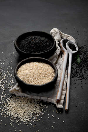 Black and white sesame seed on black background. Organic food conceptの写真素材