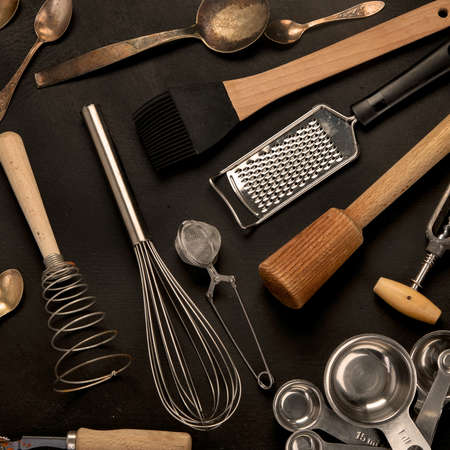 Set of kitchen utensils on black background. Tools for cooking. Top view
