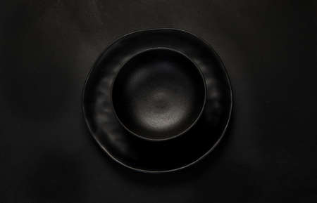 Table setting with a black plates on a black background. Minimalism concept. Top viewの写真素材