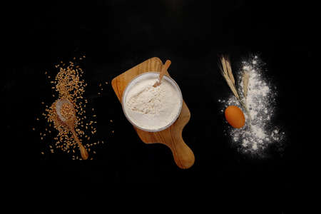Wheat flour on dark background. Food preparing concept. Top view, copy space