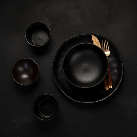 Table setting with a black plates on a black background. Minimalism concept. Top viewの写真素材