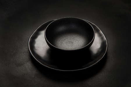 Table setting with a black plates on a black background. Minimalism concept.の写真素材