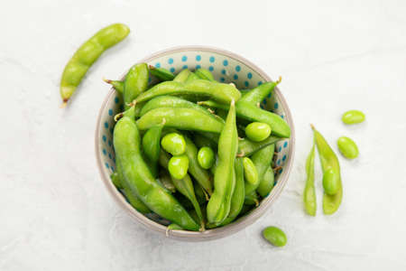 Raw edamame soya beans with salt and sauce on light gray background. Top viewの写真素材