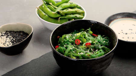 Wakame seaweed with sesame and chilli on gray background. Asian food concept.の写真素材