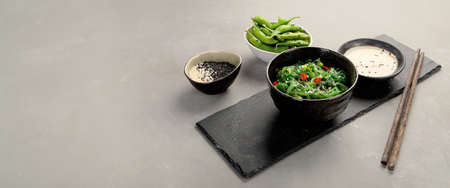 Wakame seaweed with sesame and chilli on gray background. Asian food concept. Copy spaceの写真素材