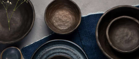 Table setting with a black and blue plates on gray background. Minimalism concept. Top view, copy spaceの写真素材