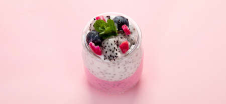 Layered chia puding with pink filling on pink background. Healthy breakfast concept.の写真素材
