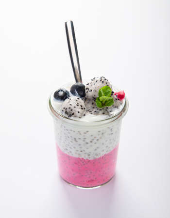Layered chia puding with pink filling on white background. Healthy breakfast concept.の写真素材