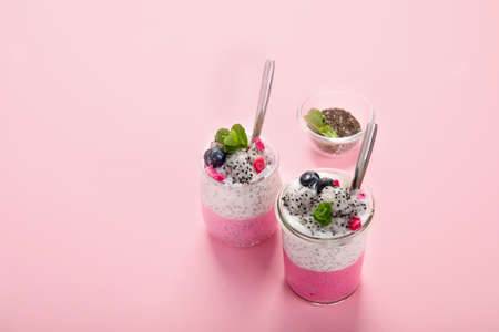 Layered chia puding with pink filling on pink background. Healthy breakfast concept.の写真素材