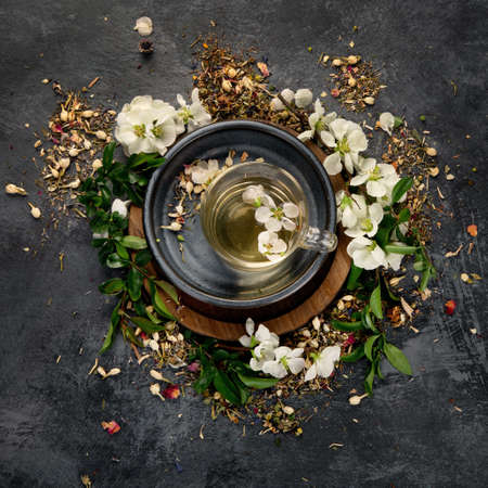 Green herbal tea with cups and teapot on gray backround. Top view