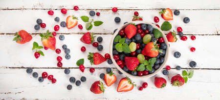 Various fresh forest berries on white background. Organic food concept. Top view, copy space, panoramaの写真素材